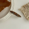 Detail showing tortoise shell pattern resin hair clip on a white ceramic plate - Lake Blue Brown