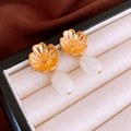 Detail of vintage golden flower earrings with white resin drops on velvet jewelry box - White Resin Flower Dangle