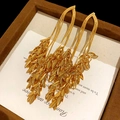 Elegant gold-plated tassel earrings with layered leaf charms on a brown velvet tray - Silver Needle / Gold