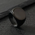 Macro view of a minimalist black stainless steel signet ring on a dark rock background - Black (circle) / Size 7