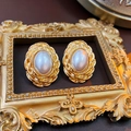 Détail de boucles d'oreilles perles ovales vintage avec cadre doré tissé sur fond sombre - Or (Tige de boucle d'oreille en argent sterling 925)