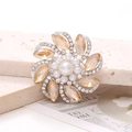 Macro shot of silver zinc alloy flower shoe charm with amber crystals and white pearls - Champagne