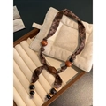 Dettaglio della collana in stile etnico con tessuto floreale marrone e perline di legno - Stile Tondo/Con Nappe (Collana-Caffè-Tondo)