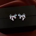 Macro shot of silver bow earrings with light blue teardrop gemstone and crystals - Silver-Blue (Bowknot Style)