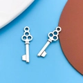 Silver-plated metal key charms for DIY jewelry making on textured leather backdrop - 1pc Antique Silver Key 7x22mm
