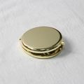 Detailed view of a gold circular folding makeup mirror on a white linen texture background - 65mm / Gold
