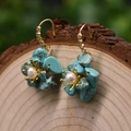 Floral earrings with turquoise petals, white pearl center and gold hooks on wood - Turquoise Flower Dangle