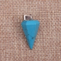 Macro detail of faceted turquoise gemstone cone pendant on a rustic linen background - Turquoise