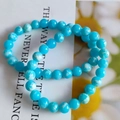 Detailed macro view of 8mm blue gradient cat eye beads bracelet on floral card - Blue Beads White Clouds