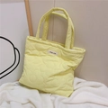 Detail of light yellow quilted tote bag with floral stitching and simple wish label - Light Yellow