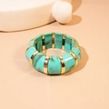 Detail of turquoise marble resin bangle with gold-tone metal segments on a beige surface - Dark Green