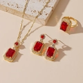 Detailed set of gold tone jewelry featuring emerald-cut red gemstones and white crystals - Ruby Red Gemstone 3-Piece Set