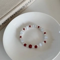 Artistic beaded bracelet with red agate and blue cat-eye stone on a white ceramic tray - Agate & Cat's Eye Stone Bracelet