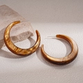 Close-up of amber resin C-shaped earrings with marble texture on light stone surface - Silver Earring Post - Coffee