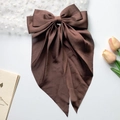 Elegant brown satin bow hair clip with long ribbons on a decorative background - Coffee