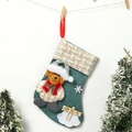 Dettaglio di calza natalizia in lino verde con orsetto 3D e cartello in legno Merry Christmas - Orso / Stile Orso Blu