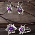 Détails d'une parure en argent avec pierres violettes sur fond en bois rustique - Parure de bijoux (Boucles d'oreilles+Bague+Pendentif) / Violet