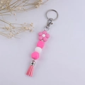 Dettaglio portachiavi con perline di silicone rosa e bianche, fiore e nappa decorativa - Rosa Rossa