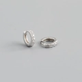 Macro detail of silver S925 huggie hoop earrings with sparkling cubic zirconia inlay - Outer Diameter 9mm / Silver
