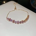 Close-up of gold French court style bracelet with pink zircons and adjustable slider - Oval Zirconia (HB4376) / Pink