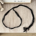 Detail of a handmade black woven bohemian waist belt with dark beads on marble - Multi-Layer Woven Wood Bead 4-Section Black