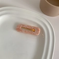 Detail view of pink marble acetate hair clip on a decorative white porcelain plate - Pink Square
