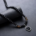 Tiger eye beaded necklace for men with black octagonal gemstone pendant on textured background - Obsidian Tiger Eye Pendant Necklace