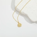 Minimalist gold necklace with a round paw print pendant on a white stone background - Gold Paw Print