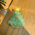 Detailed macro view of a Christmas tree-shaped resin clip with green sequins and a star - Star Christmas Tree
