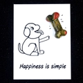 Green and red crystal bone figurine on a white card with dog illustration - Unakite