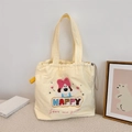 Détail de la broderie de chien mignon et lettrage Happy sur le sac cabas en toile jaune - Chien avec Grand Nœud