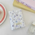 Close-up of quilted white passport case with purple teddy bear pattern and fabric label - Star Bear