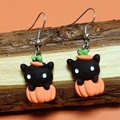 Detail of Halloween drop earrings featuring resin black cat and orange pumpkin on wood - Black Ear Cat with Pumpkin
