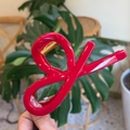 Macro detail of glossy red bow hair claw clip with a strong golden metal spring - China Red