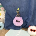 Close-up of a cute purple fuzzy pom-pom keychain ornament with tiny pink sunglasses - Purple