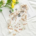 Detail of floral chiffon hair scrunchie with long ribbon scarf on a cream base - White