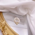 Detail of freshwater pearl ring with a gold S-letter pendant on a mirror surface - Letter S