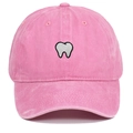 Detailed close-up of pink washed cotton baseball cap with white tooth embroidery - Pink