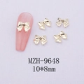 Macro detail of gold bow-shaped alloy nail art charms size 10x8mm on pink display - Gold Bowknot-9648