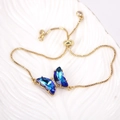 Detailed macro view of a gold chain bracelet with a blue gradient crystal butterfly pendant - Gradient Blue