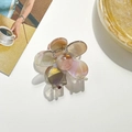 Détail de la pince à cheveux fleurie translucide avec dégradé rose et doré nacré - café