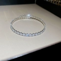 Macro-opname van een zilveren armband met een rij sprankelende rechthoekige zirconia - Rechthoekige Open Stijl / Zilver