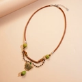 Collier style bohème avec cordon en cuir marron, pendentif papillon et perle verte - Collier-Vert