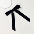 Detalle de la suave textura de terciopelo negro en un pasador de pelo con cintas largas - Negro