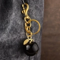 Vintage golden keychain with a polished black apple pendant and brass finish clasp - Black