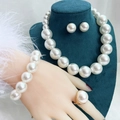 Elegant white pearl jewelry set with necklace and earrings on dark green velvet bust - White