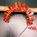 Makro-Detail des roten Kristall-Boho-Kronen-Haarreifens mit Silberdrahtwicklung auf Holz - Roter Achat