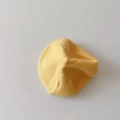 Detailed close-up of a bright yellow knitted beret hat showing soft fabric texture - Yellow