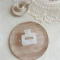 Close-up of a square acetate hair claw with iridescent pearl finish on a wooden tray - Small Square / AB White
