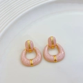 Makroansicht französischer Vintage-Ohrringe mit rosa Marmortextur und Goldbeschichtung - Kirschblütenrosa